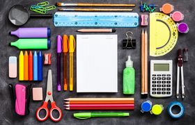 Top view of a large group of school or office supplies on black background